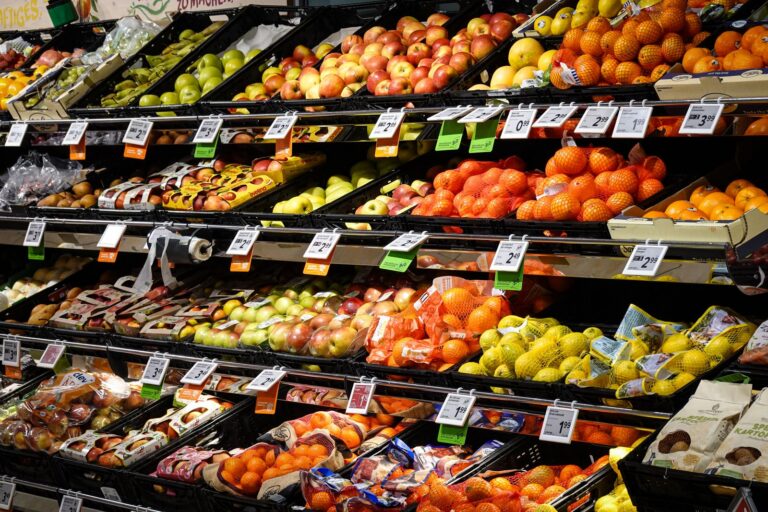 Colorful assortment of fresh fruits neatly arranged on supermarket shelves, ideal for healthy eating themes.