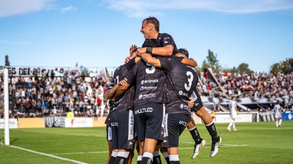 Exciting soccer match moment with team celebrating a goal on the field.