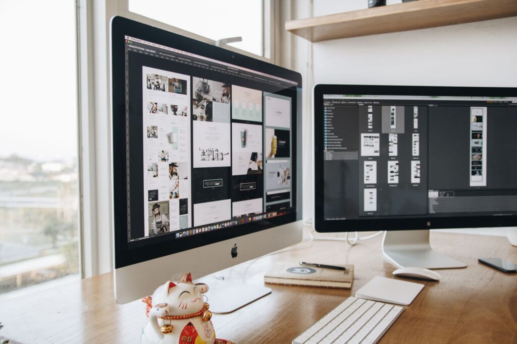 A stylish workspace featuring dual monitors and a lucky cat figurine, ideal for technology and design themes.
