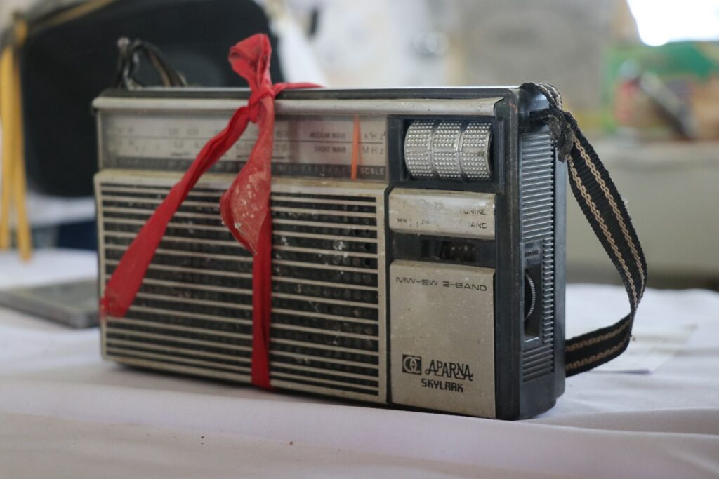 Classic vintage radio adorned with a red ribbon, showcasing retro style indoors.