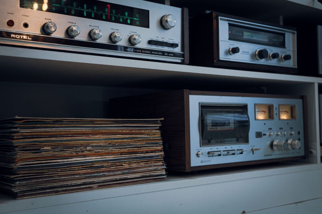 Retro audio setup featuring a vintage record player, tape deck, and classic stereo equipment alongside a stack of vinyl records.