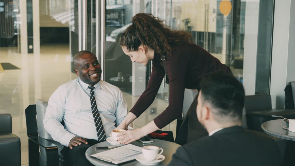 Business professionals enjoying coffee during a casual meeting at a café.