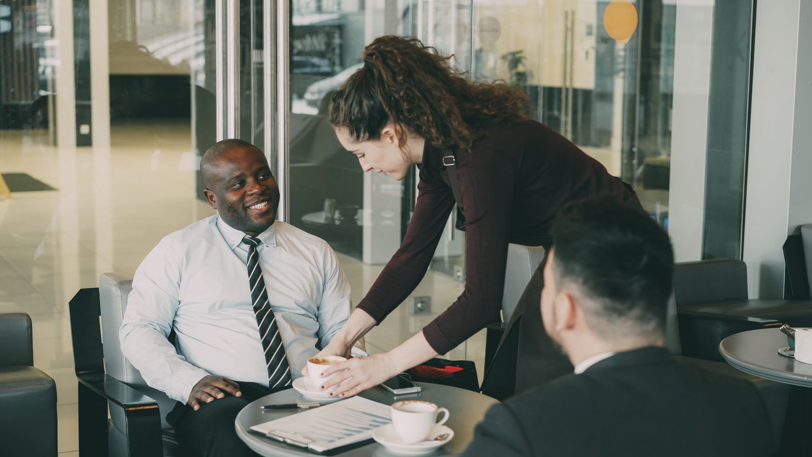 Business professionals enjoying coffee during a casual meeting at a café.