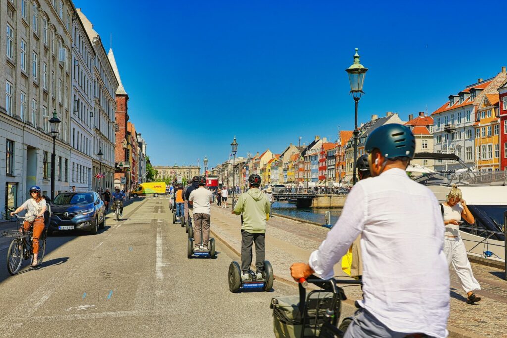 People riding segways down a sunny city street.