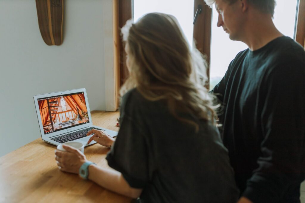 A couple viewing home interior design on a laptop while enjoying coffee together indoors.