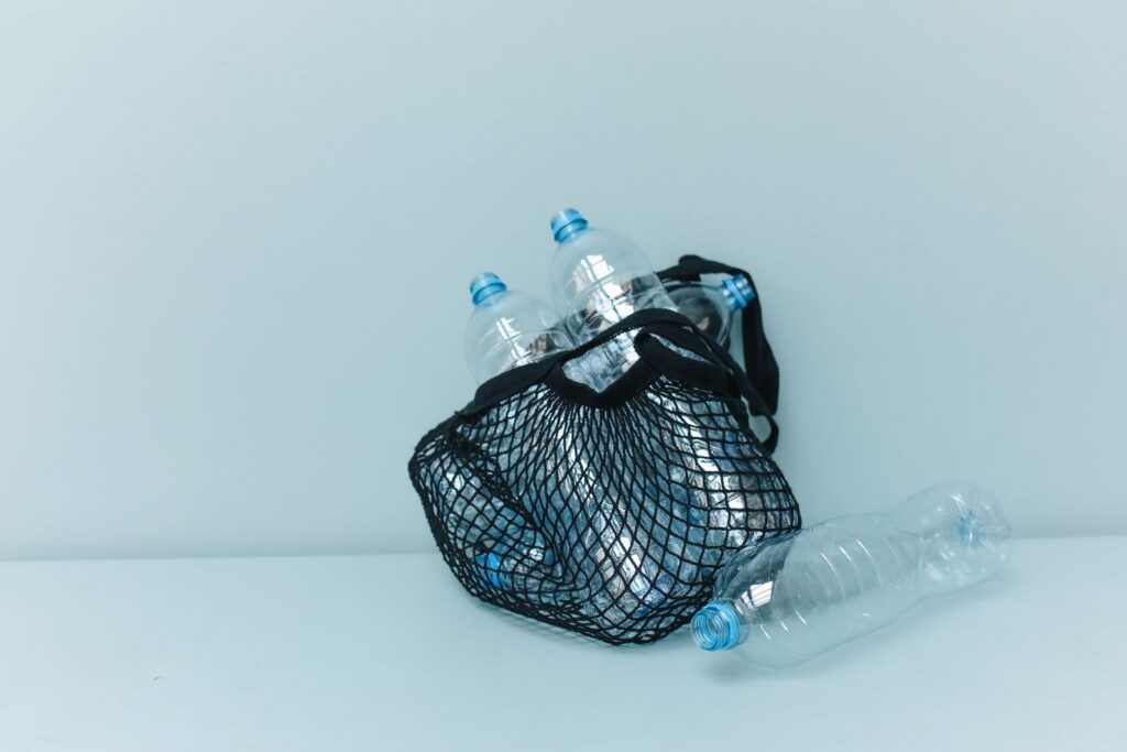 A reusable mesh bag filled with plastic bottles, highlighting the concept of sustainability and plastic pollution.