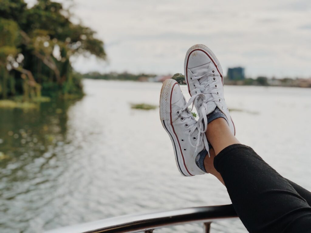 Enjoying a relaxing moment by the tranquil waters in Alappuzha, India, with sneakers on.