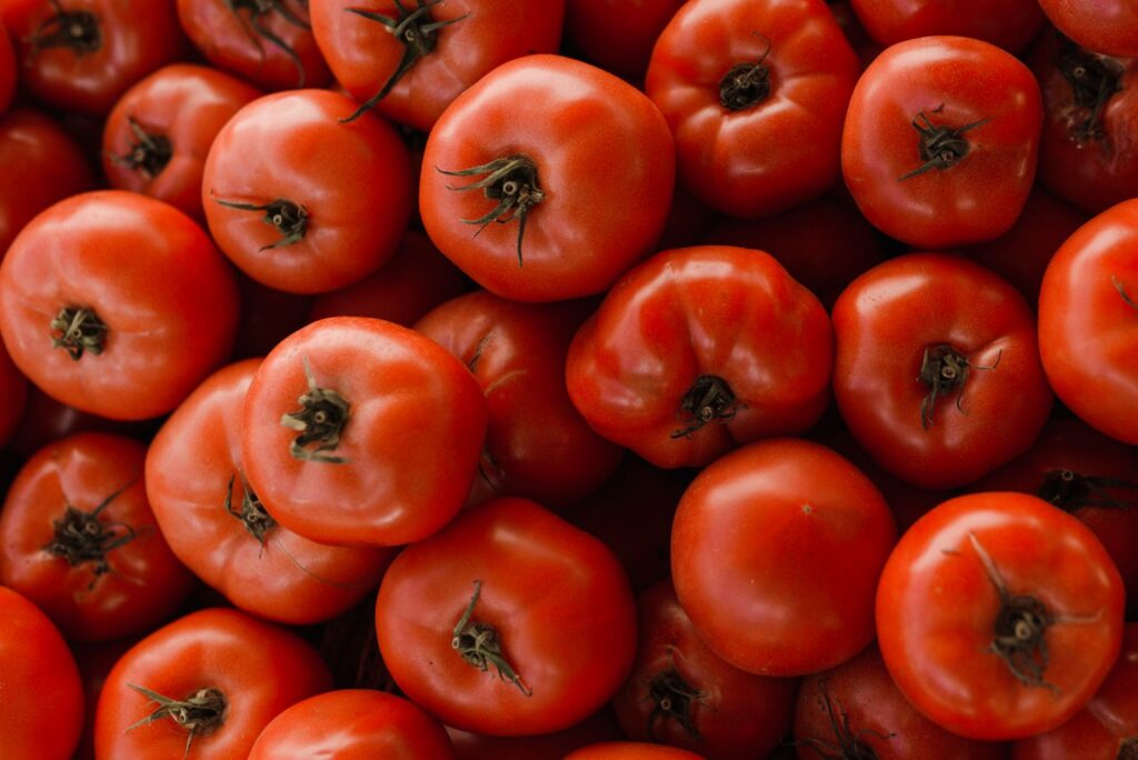 A detailed close-up of fresh, ripe red tomatoes showcasing their natural texture and vibrant color.