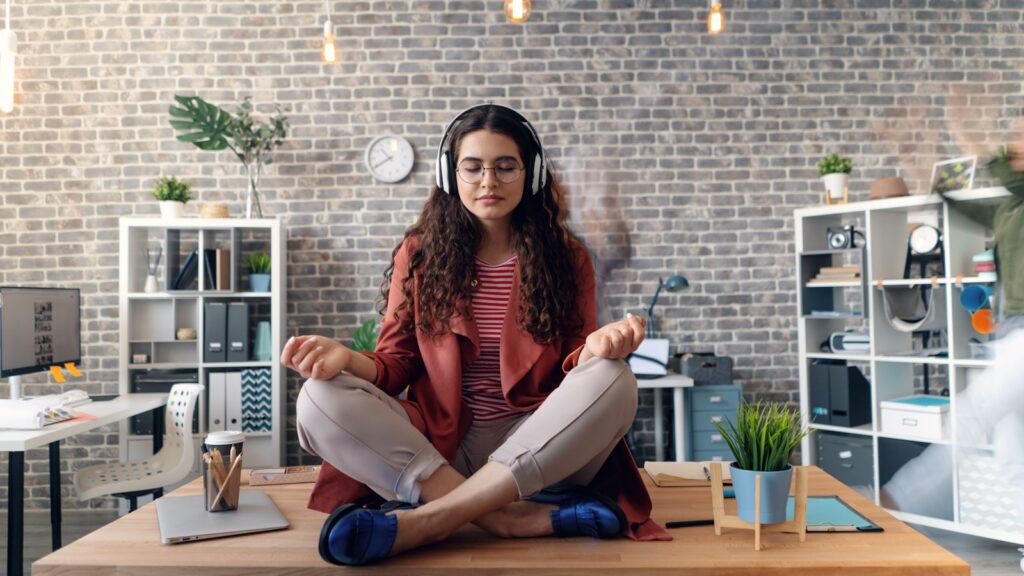 a woman sitting on a desk with headphones on