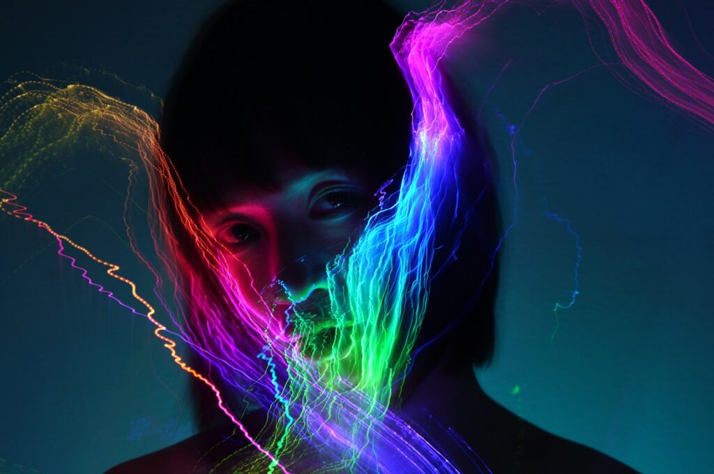 A dark silhouette with colorful light streaks.