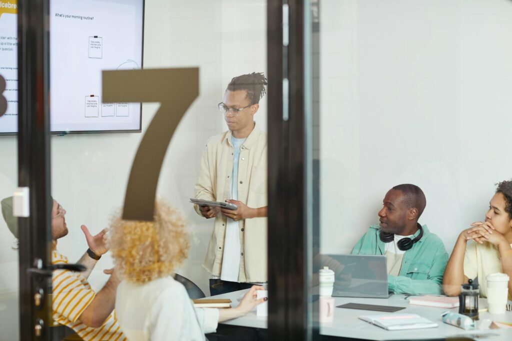 A diverse team collaborates in a modern conference room, engaging in a planning session.