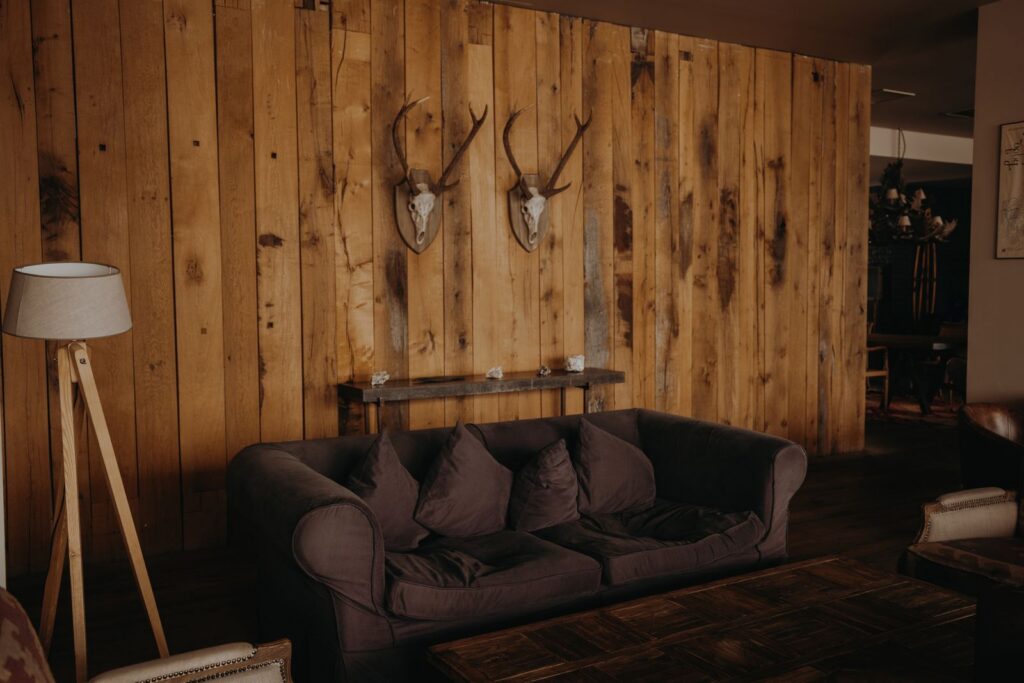Warm and inviting living room with rustic wooden wall and cozy furniture.