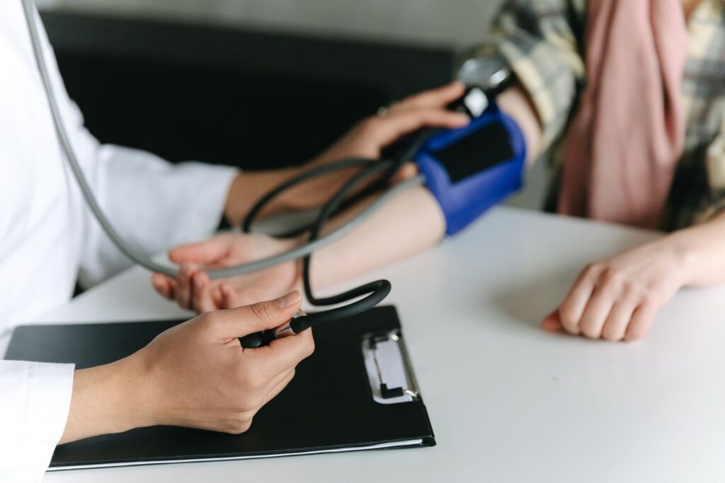 Close-up of a medical professional measuring a patient's blood pressure at a clinic.