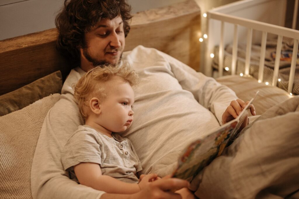 A father and child share a warm moment reading together before bedtime.
