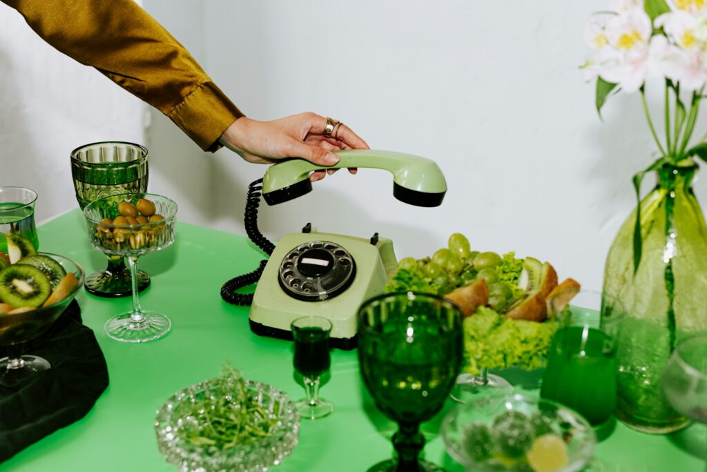 A table topped with a green table cloth covered in dishes and glasses