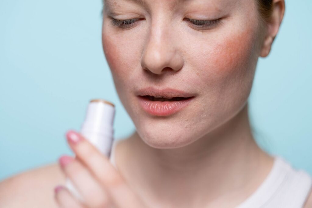 Close-up of a woman applying multipurpose make-up stick for cheeks and lips