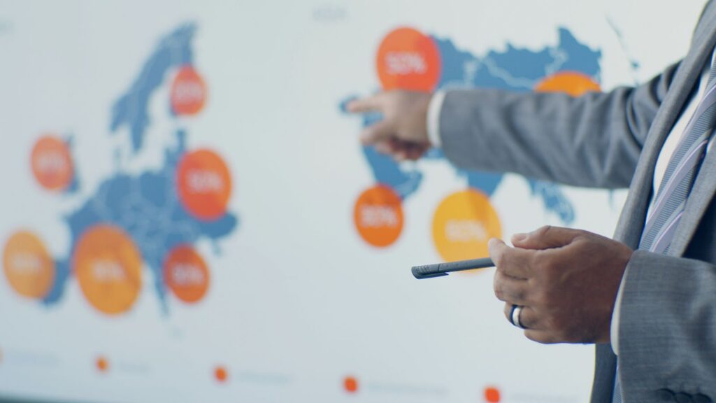 Professional presenting detailed analytics on European map during office meeting.