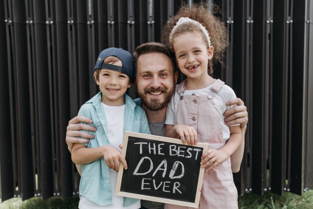 A joyful father hugging his children with a 