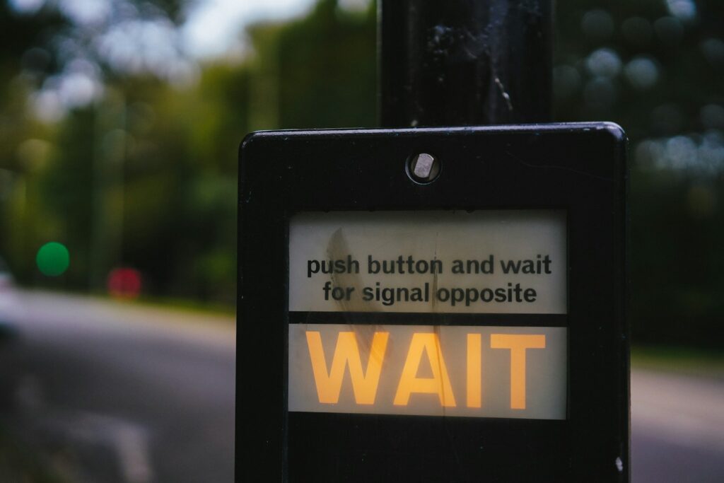 a sign that says push button and wait for signal opposite
