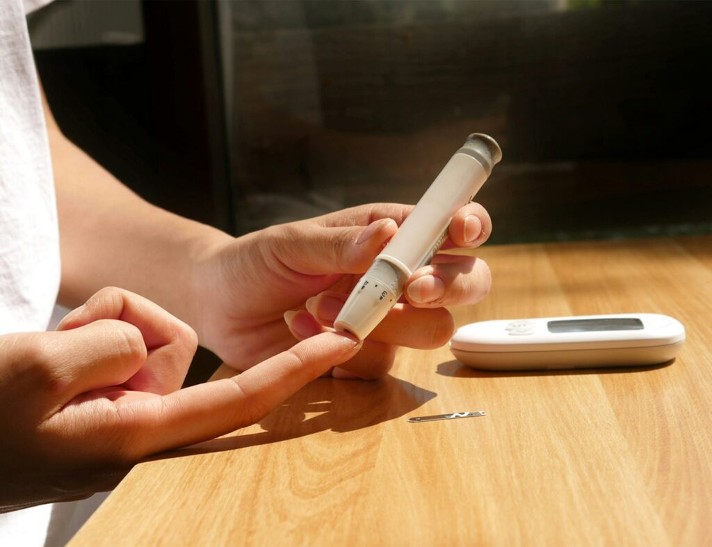 Person using glucometer to take blood sugar levels
