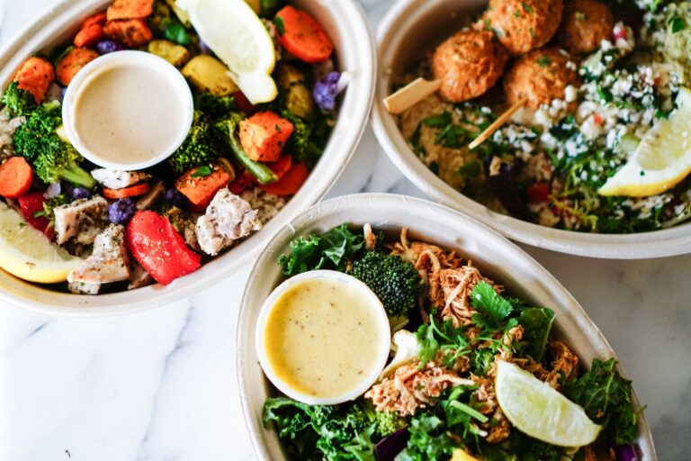 Vibrant flat lay of nutritious meal bowls with roasted vegetables, salads, and sauces.