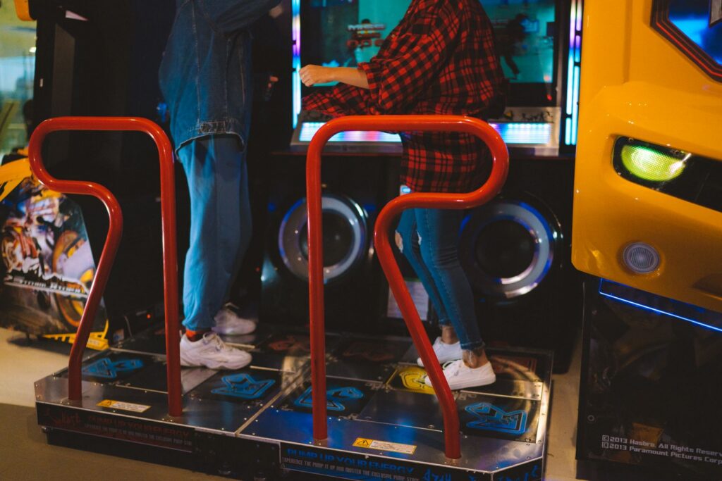 Adults having fun on a dance arcade game indoors. Vibrant, recreational, gaming fun.