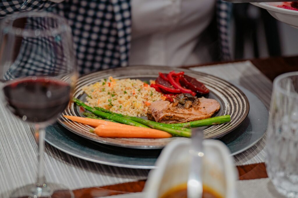 a plate of food on a table with a glass of wine