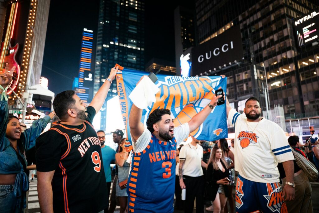 New york knicks fans celebrate in times square at night.