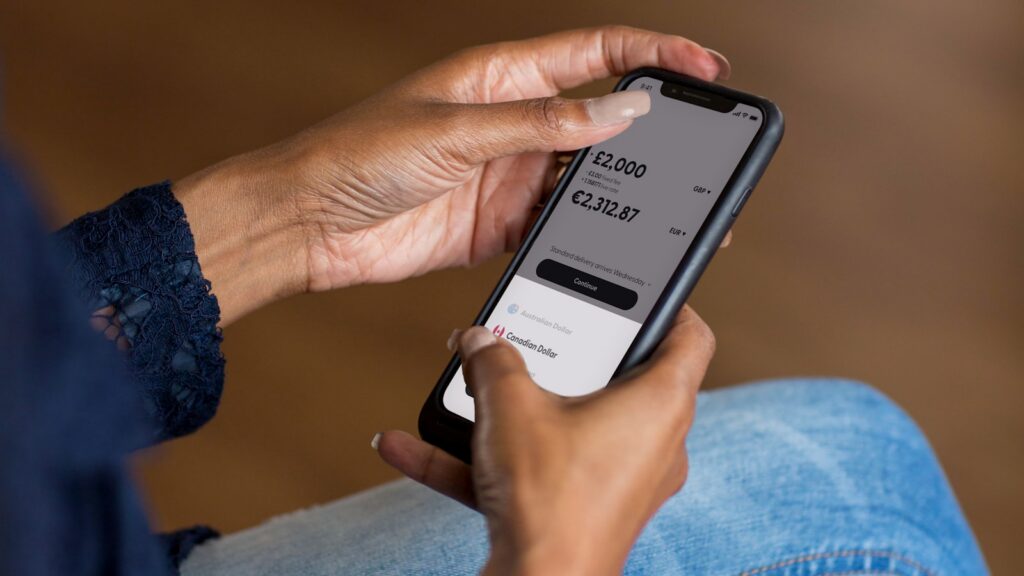 a woman holding a cell phone with savings app in her hand