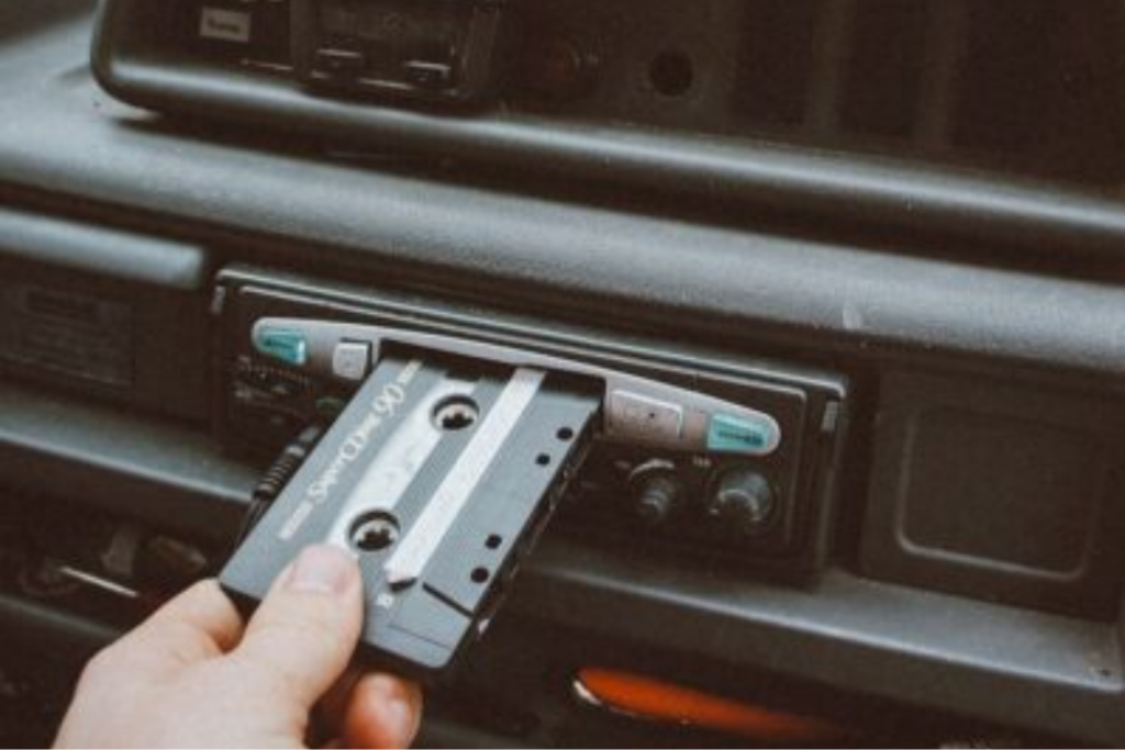 person inserting cassette tape on cassette player