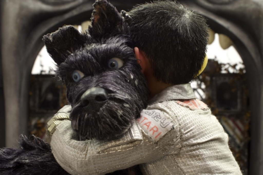Isle of Dogs still boy hugging black dog