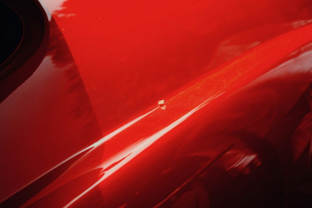 A close-up abstract of a shiny red car surface.