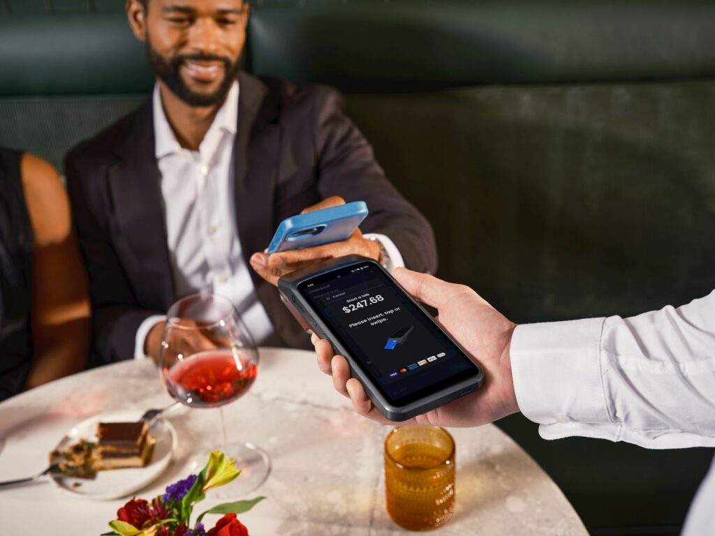 Man paying with phone at restaurant table