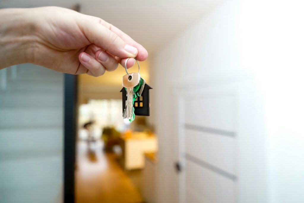 Holding house keys in front of the entrance.