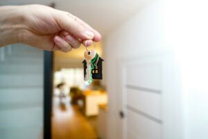 Holding house keys in front of the entrance.
