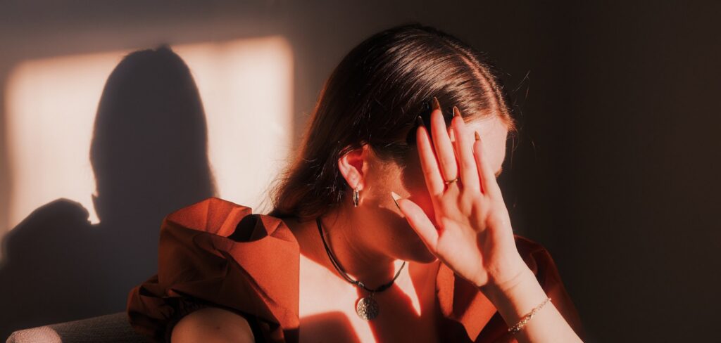 A woman sitting in a chair with her hands on her face