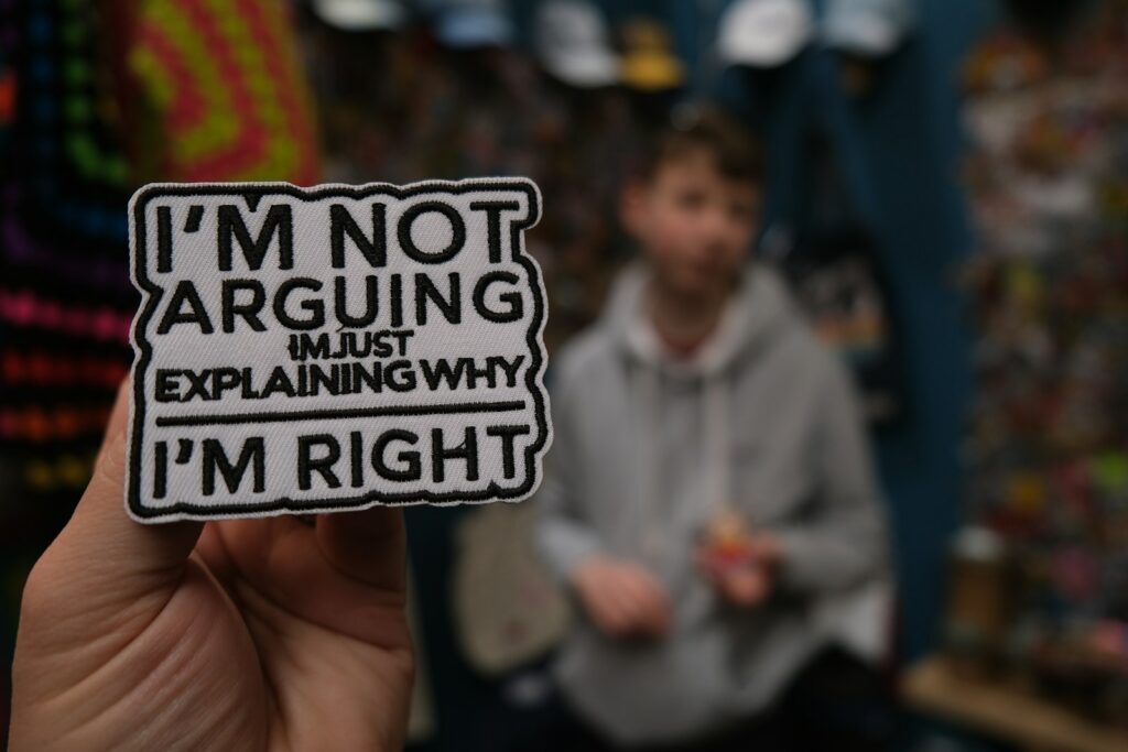 Hand holding a sticker that says i'm not arguing.