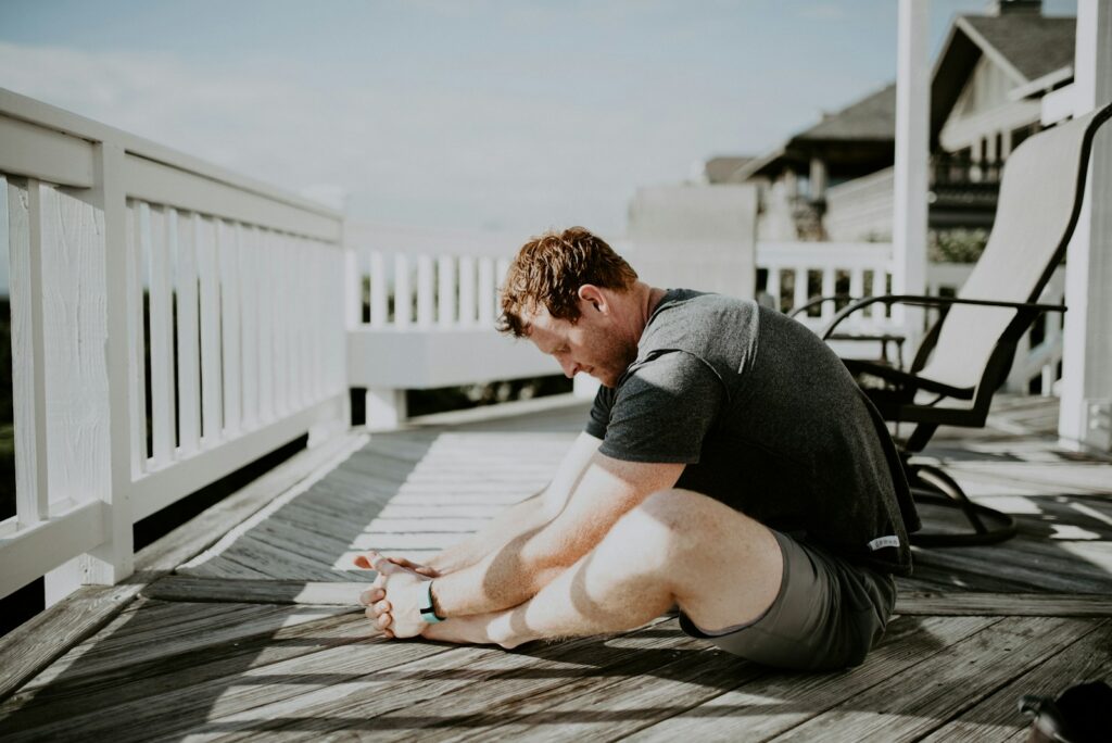 man doing yoga morning stretch in porch