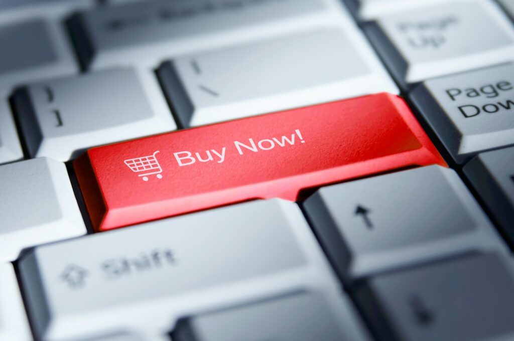 Red 'buy now!' button on a computer keyboard.