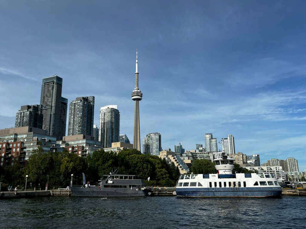 Toronto skyline with cn tower and ferries on water