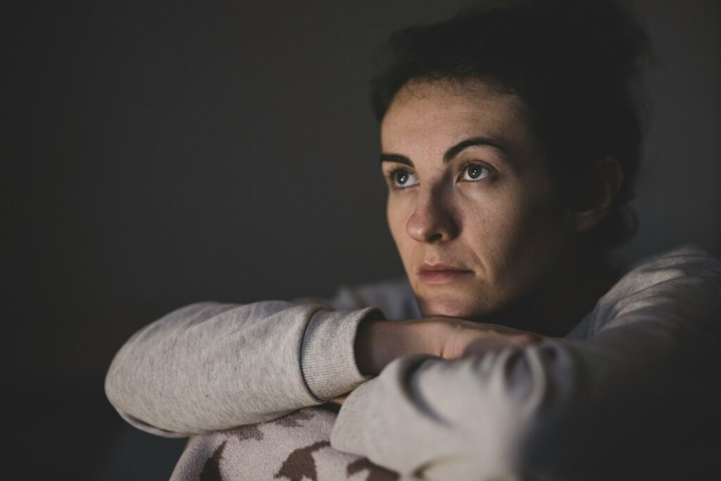 Woman in gray long sleeve shirt looking emotionally drained