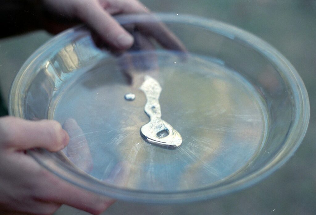 Liquid mercury in a clear glass dish.