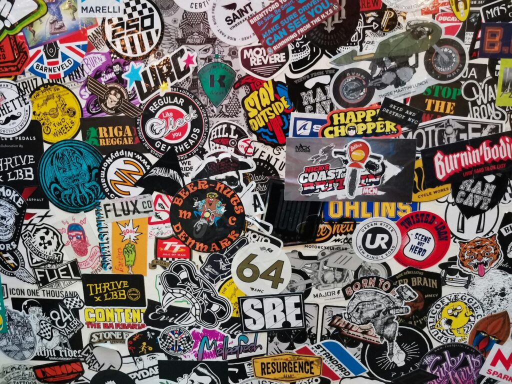 A wall is covered with many different stickers.