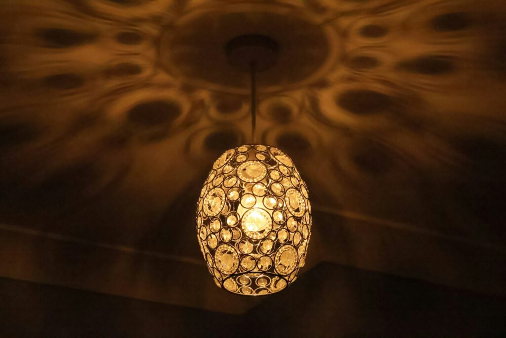 Ornate pendant light casting decorative shadows on ceiling