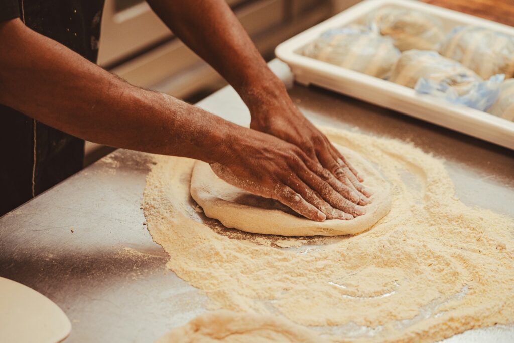 a person kneading dough on top of a table