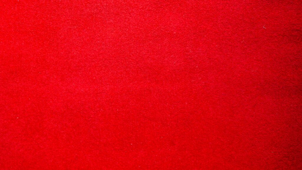 a red carpet with a black cat laying on top of it