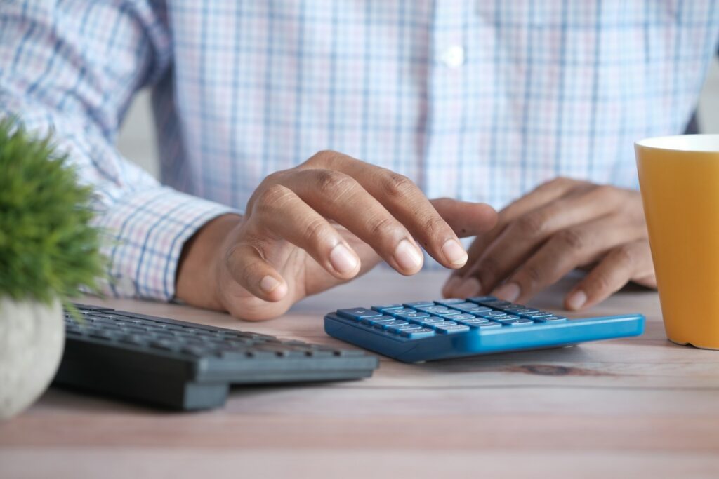 person using calculator to compare loan refinance options