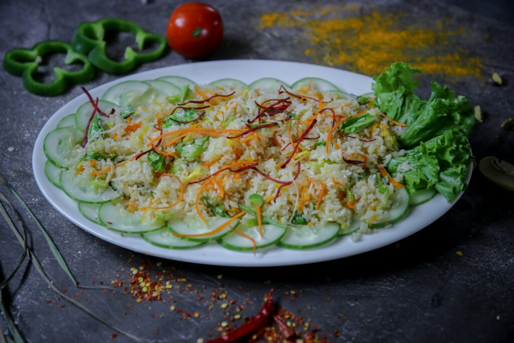 A plate of rice salad with cucumber and vegetables.