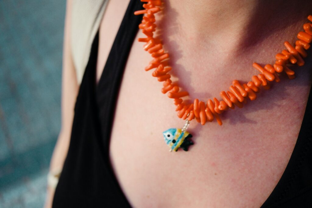 Orange coral necklace with a unique blue eye pendant.