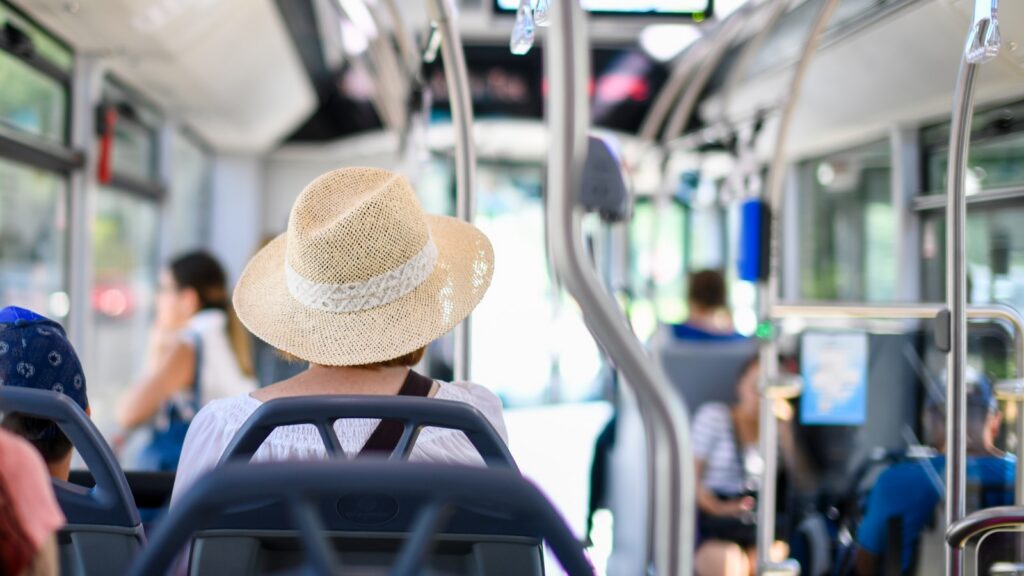 Woman wearing a straw hat on a bus